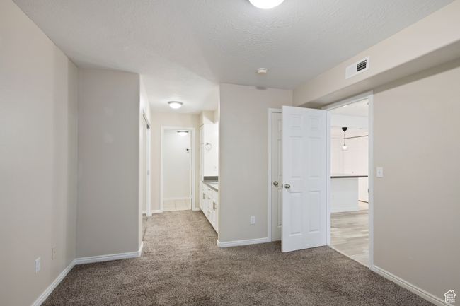 Carpeted empty room with visible vents, a textured ceiling, and baseboards | Image 14