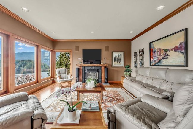 Living room featuring baseboards, recessed lighting, a glass covered fireplace, and light wood-type flooring | Image 20