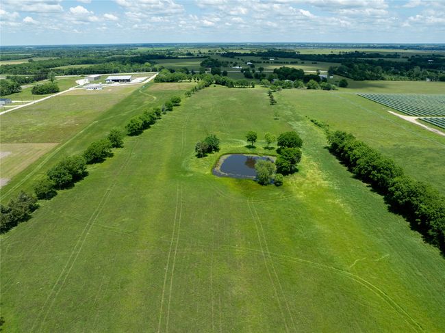 Aerial view of sparsely populated area featuring rows of crops | Image 5
