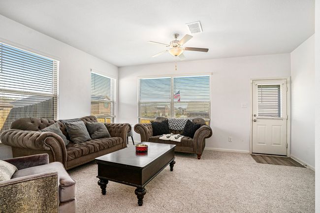 Living room with baseboards, carpet floors, ceiling fan, and visible vents | Image 4