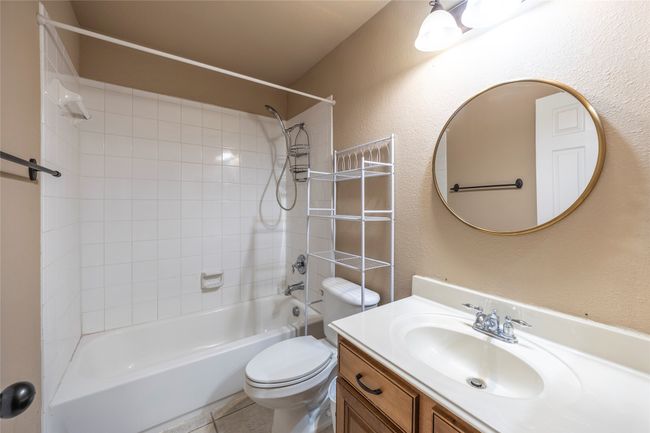 Bathroom with shower / washtub combination, vanity, tile patterned floors, and a textured wall | Image 27