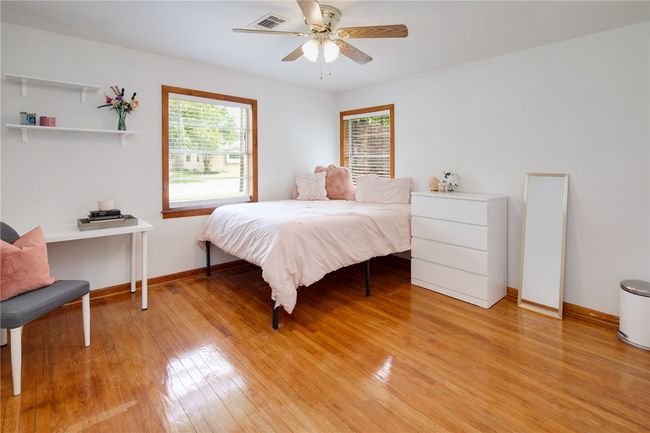 Bedroom with light wood finished floors, baseboards, and ceiling fan | Image 17