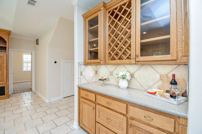 Elegant dry bar with built-in wine rack and ample storage, perfect for entertaining in style. | Image 21