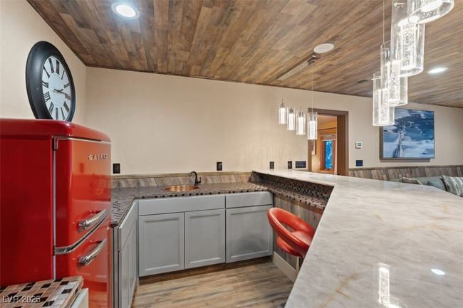 Kitchen with recessed lighting, a sink, light wood-type flooring, wooden ceiling, and fridge | Image 50