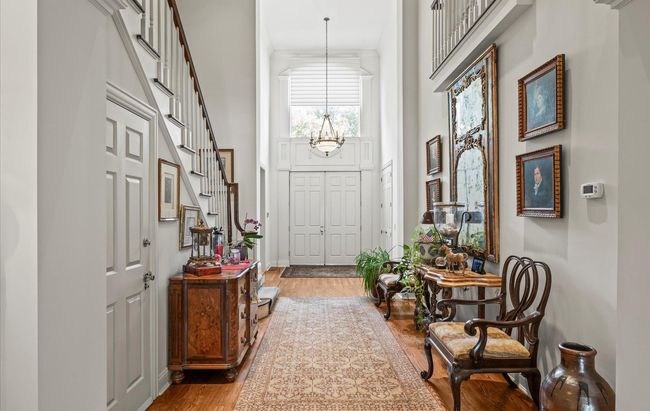 Entryway featuring a towering ceiling and wood finished floors | Image 9