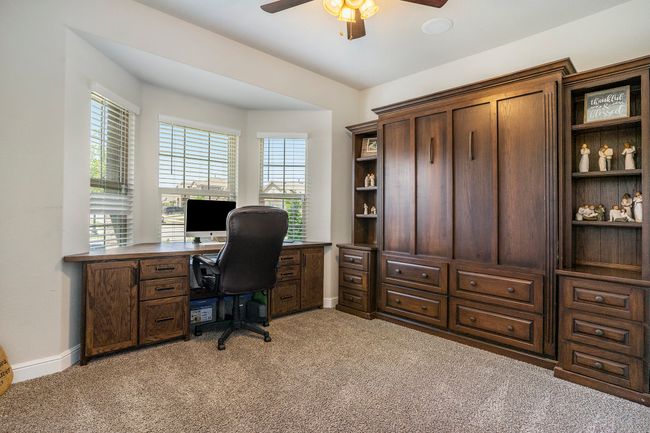 Office area / bedroom with light carpet, a healthy amount of sunlight, and a ceiling fan. | Image 12