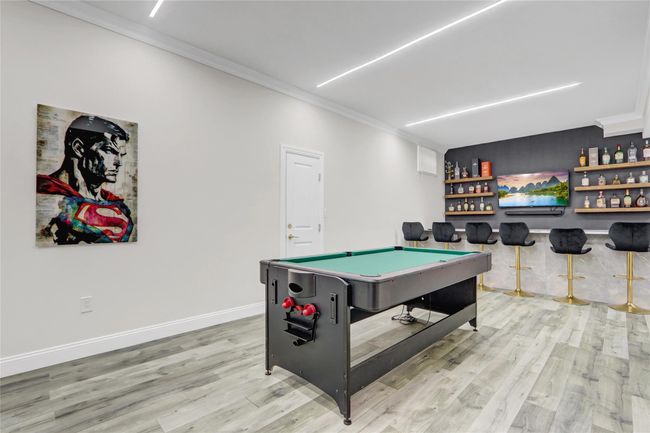 Recreation room featuring a dry bar, ornamental molding, pool table, light wood finished floors, and baseboards | Image 27