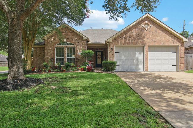 Charming brick home with great curb appeal, featuring a well-maintained lawn, mature trees, and a welcoming front porch. The two-car garage and driveway provide ample parking space. Ideal for families seeking a cozy and inviting atmosphere. | Image 28