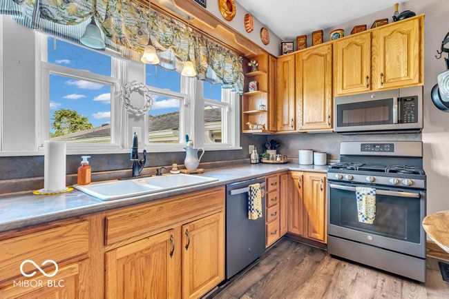 kitchen with appliances with stainless steel finishes, wood finished floors, and open shelves | Image 26