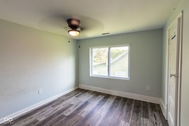 unfurnished bedroom featuring baseboards, dark wood finished floors, ceiling fan, and visible vents | Image 29