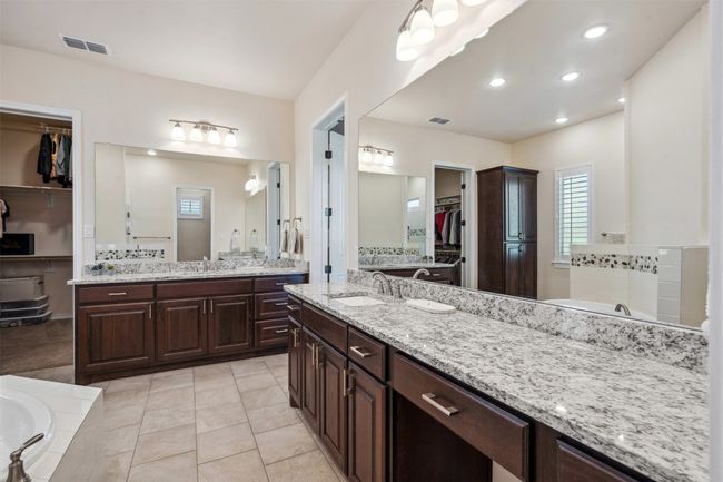 Bathroom featuring a spacious closet, visible vents, a garden tub, and a sink | Image 28
