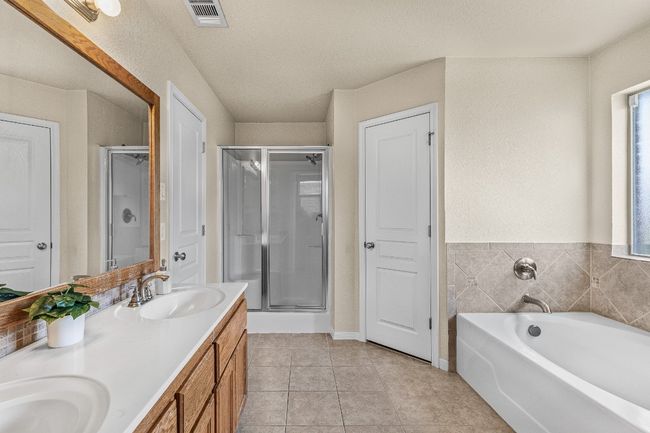 Bathroom with a shower stall, double vanity, a garden tub, and tile patterned floors | Image 11