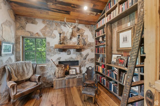 Living area with hardwood / wood-style flooring, a stone fireplace, and a wooden ceiling with exposed beams | Image 15