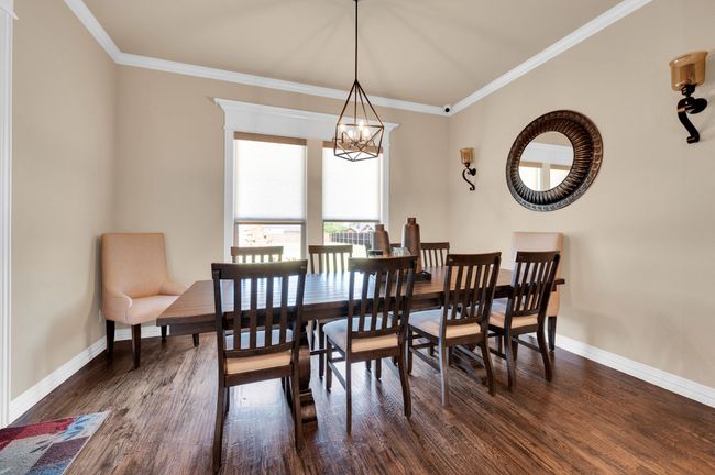 Dining room with a chandelier, crown molding, and dark wood-style floors | Image 14