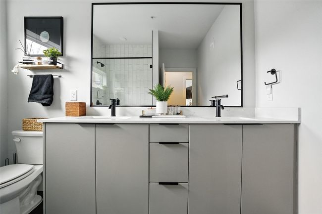 Bathroom featuring double vanity and a shower stall | Image 17