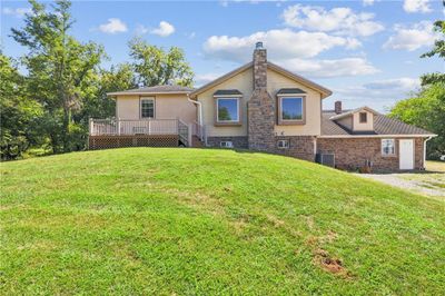 View of front facade featuring a front yard, cooling unit, and a wooden deck | Image 2