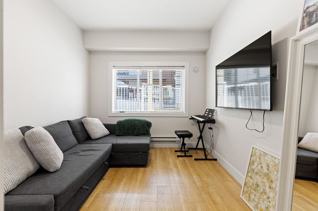 Living room featuring a baseboard heating unit, light wood-style flooring, and baseboards | Image 17