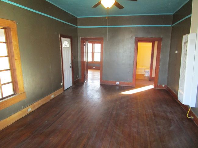 Unfurnished room with baseboards, crown molding, ceiling fan, and wood finished floors | Image 11