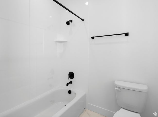 Bathroom featuring marble finish floor, toilet, shower combination, and baseboards | Image 12