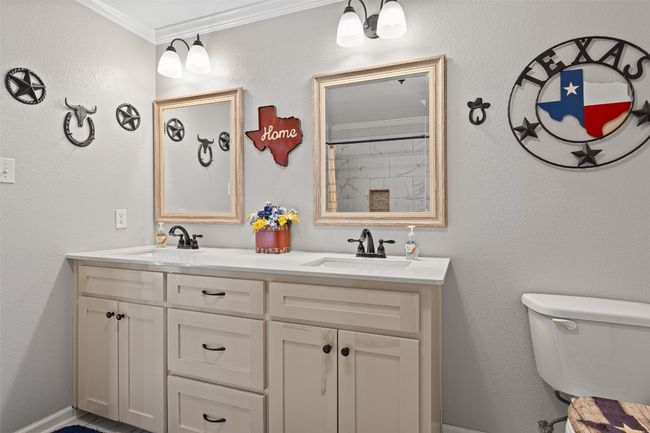 Bathroom featuring toilet, ornamental molding, a sink, and double vanity | Image 26