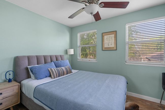 Bedroom with a ceiling fan, baseboards, and wood finished floors | Image 32