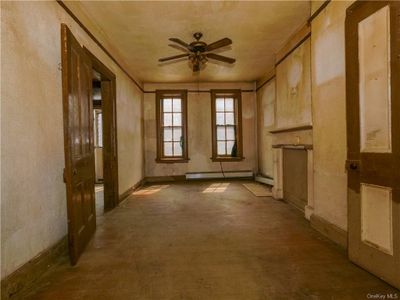 Empty room featuring ceiling fan and a baseboard radiator | Image 3