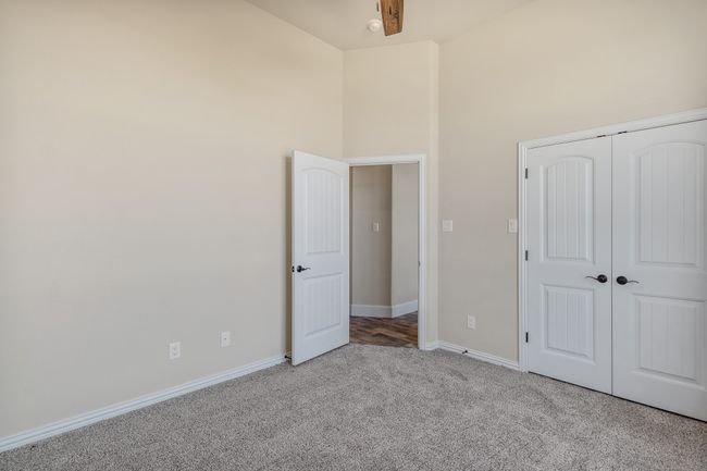 Unfurnished bedroom featuring carpet floors, baseboards, a towering ceiling, and a closet | Image 21