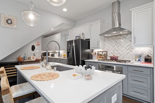 Kitchen featuring tasteful backsplash, wall chimney exhaust hood, light countertops, and recessed lighting | Image 7