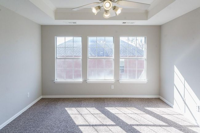 Carpeted spare room with ornamental molding, a tray ceiling, and visible vents | Image 17