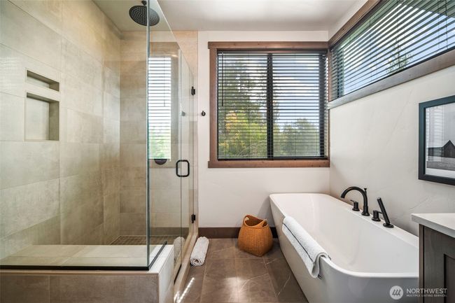 Whether you enjoy a deep soak in the tub at the end of your day or a warm shower - main floor primary en suite offers both in luxurious manner | Image 11