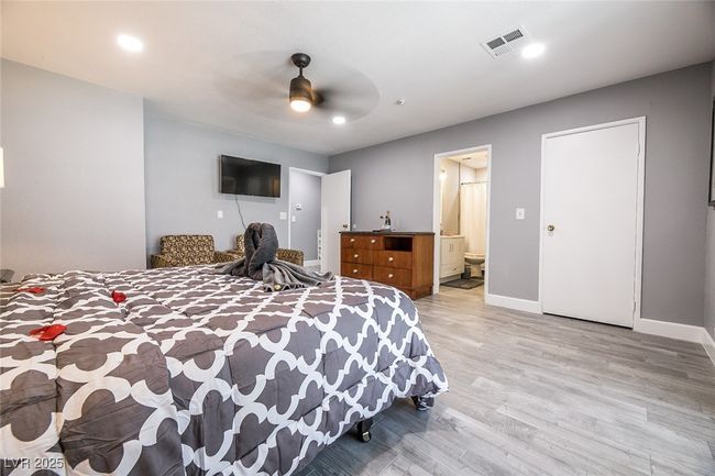 Bedroom featuring light wood-style floors, baseboards, ensuite bath, a ceiling fan, and recessed lighting | Image 37