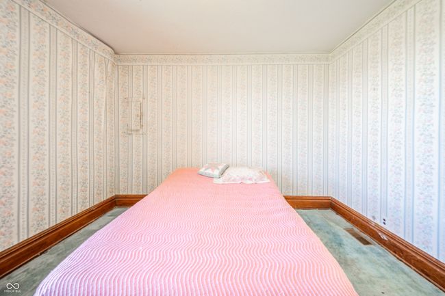 carpeted bedroom featuring visible vents, baseboards, and wallpapered walls | Image 11