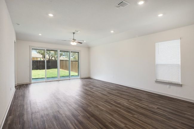 Living room featuring ceiling fan, dark wood-style flooring, recessed lighting, and lofted ceiling | Image 4