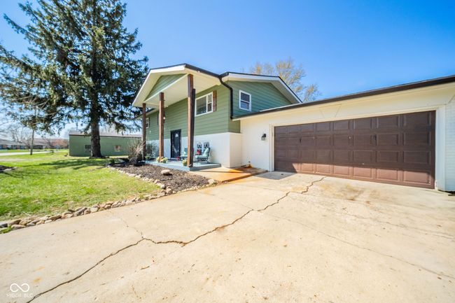 view of front facade featuring a front yard, brick siding, driveway, and an attached garage | Image 39