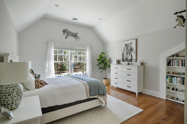 Bedroom with vaulted ceiling, visible vents, and wood finished floors | Image 24