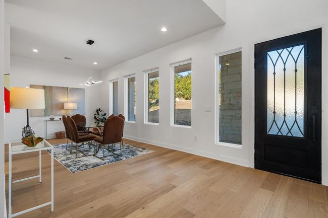 High-end interior features include impressive 8-foot doors, soaring ceilings, elegant chandeliers, recessed lighting, French doors, and a smart thermostat for modern convenience | Image 16