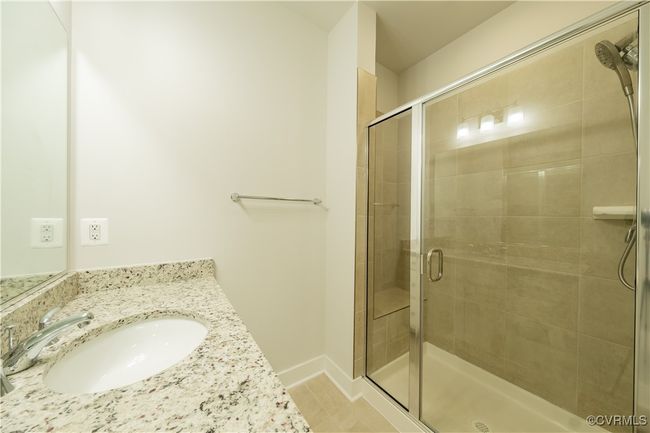 Bathroom with vanity, a stall shower, baseboards, and tile patterned floors | Image 39