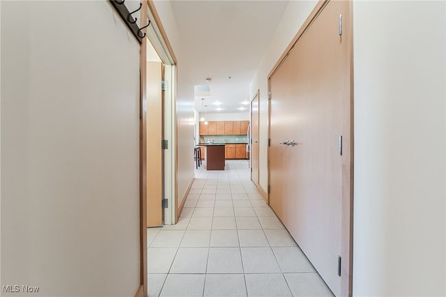 Corridor featuring light tile floors and a large closet. | Image 6