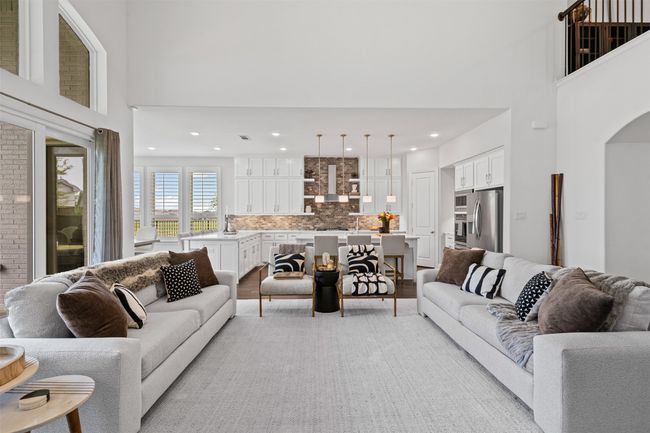 Living area featuring a towering ceiling, arched walkways, light wood-style floors, and recessed lighting | Image 10