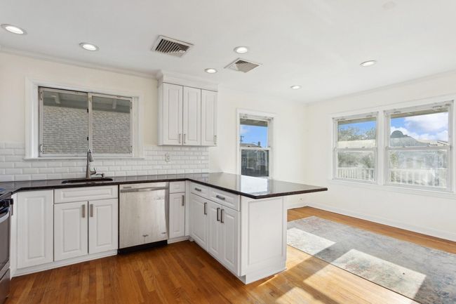 Kitchen featuring a peninsula, stainless steel appliances, a sink, and visible vents | Image 12