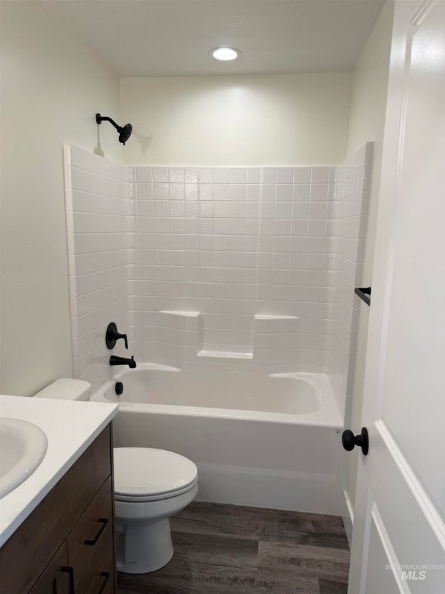Bathroom with wood finished floors, vanity, and shower / bath combination | Image 11