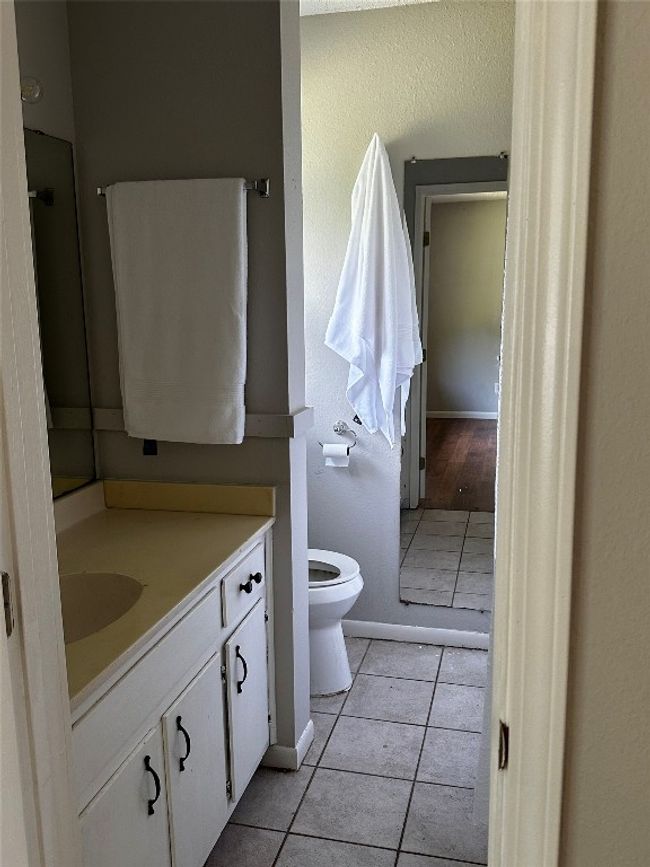 Bathroom featuring a textured wall, tile patterned floors, and vanity | Image 14