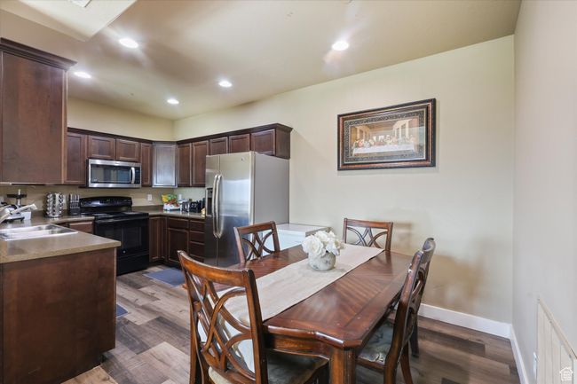 Dining area featuring dark wood-type flooring, visible vents, recessed lighting, and baseboards | Image 5