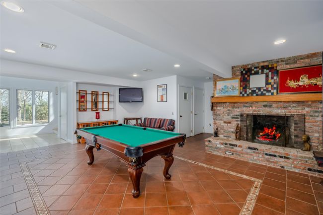 Recreation room featuring tile patterned flooring, visible vents, recessed lighting, and a brick fireplace | Image 29
