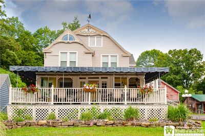 This large Victorian home has gleaming original maple floors, beautiful unpainted wood work a large dining room and beautiful bar and versatile kitchen. There are 4 ensuite bedrooms upstairs and 2 1/2 baths on the first floor. The large open front porch is entered through another large enclosed porch. A true beauty ! | Image 1