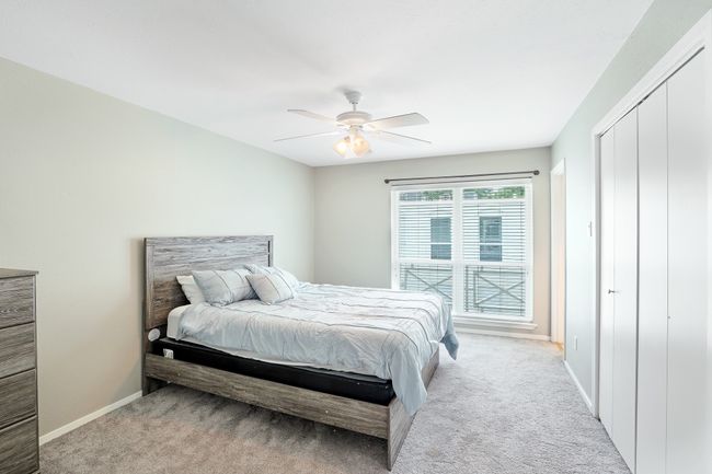 Bedroom with light carpet, baseboards, and ceiling fan | Image 11