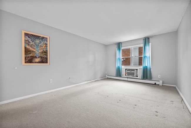 Spare room featuring carpet flooring and a baseboard radiator | Image 21