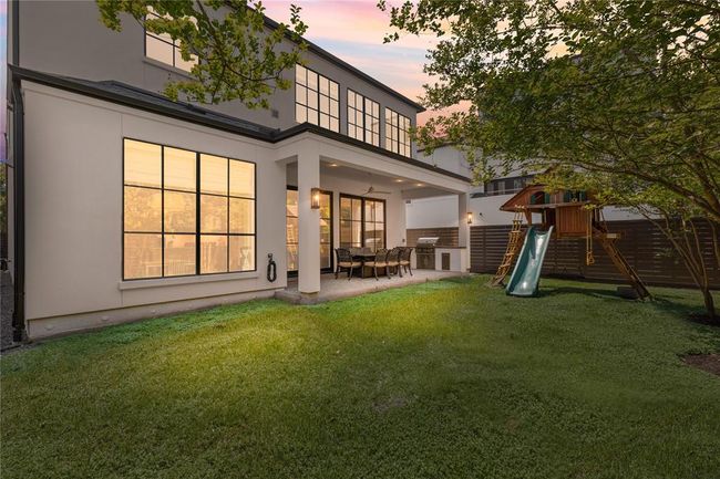 Covered patio w/ outdoor built in kitchen featuring Edgestar gas grill, trash receptacle, stainless cabinet, granite countertop. | Image 45
