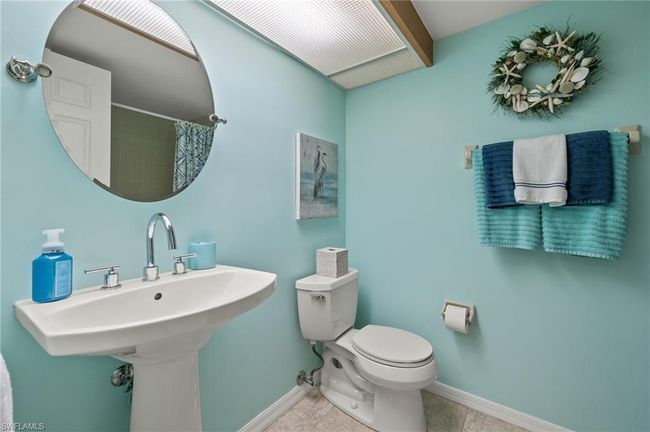 Bathroom featuring a shower with curtain, sink, toilet, and tile patterned floors | Image 19