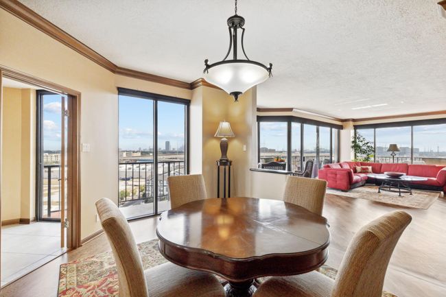 Living room flows seamlessly into a dining room with warm paint and beautiful crown molding. | Image 9